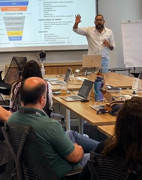 Marcelo Sales apresentando um funil de vendas para uma turma em sala de treinamento